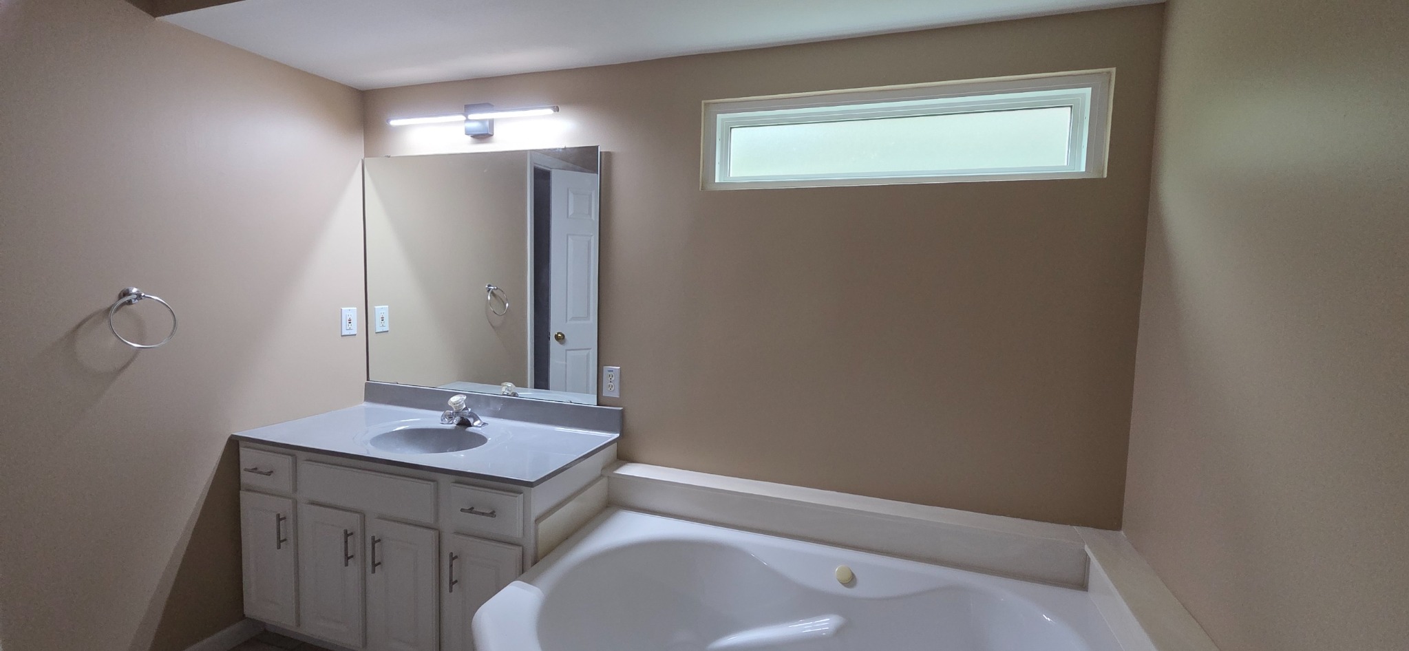 Completed bathroom repair with smooth painted walls, finished vanity area, and repaired wall beneath the window