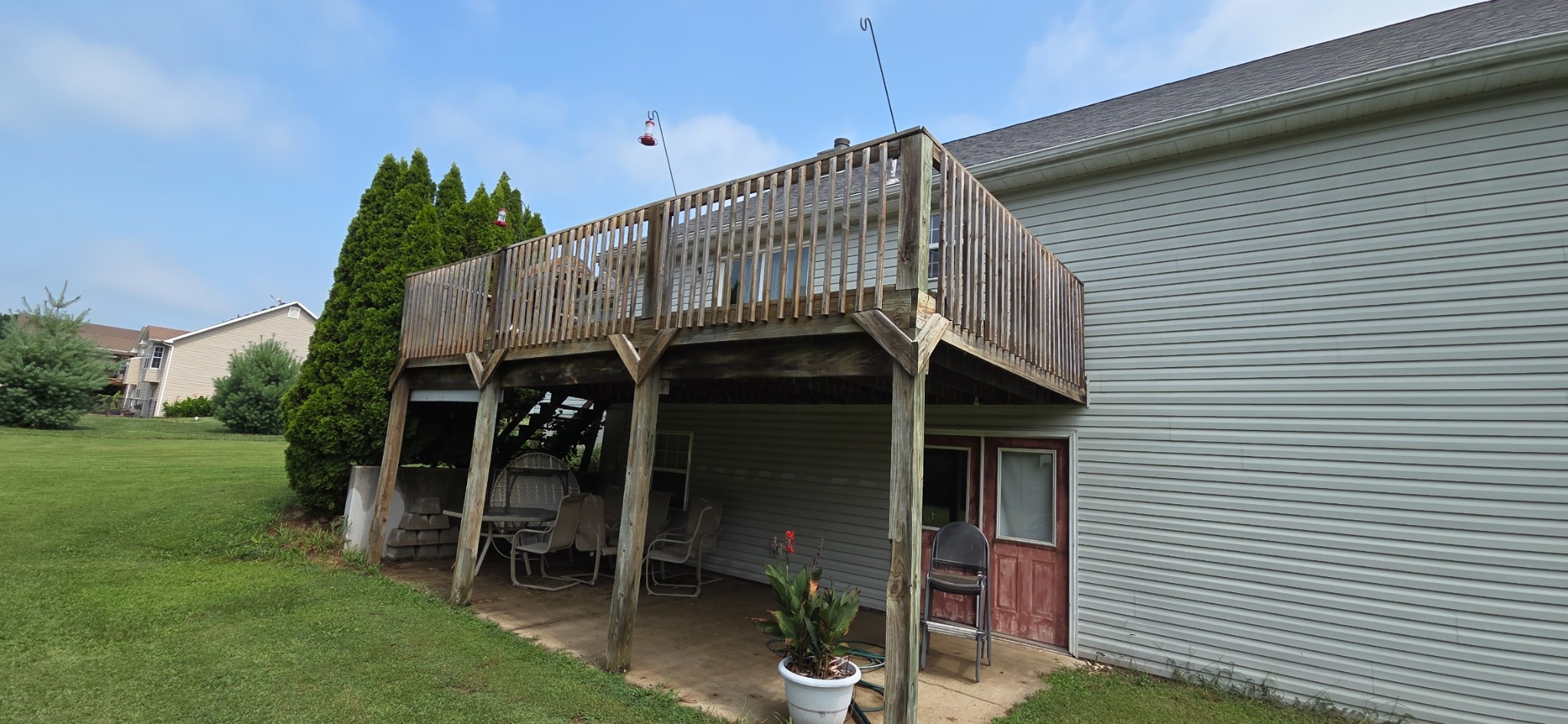 Elevated deck before repairs, with weathered wood railings and support posts